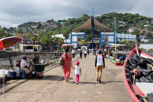 People walking in "El Malecón" towards the beach at Sunset Park in La Libertad, El Salvador, Central America