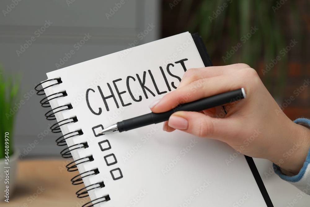Woman filling Checklist with pen indoors, closeup Woman filling Checklist with pen indoors, closeup