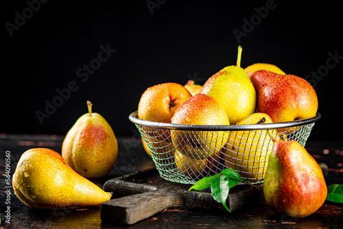 Pears in a colander on a cutting board. 