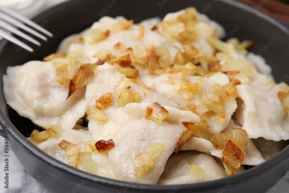 Cooked dumplings (varenyky) with tasty filling and fried onions in frying pan, closeup Cooked dumplings (varenyky) with tasty filling and fried onions in frying pan, closeup