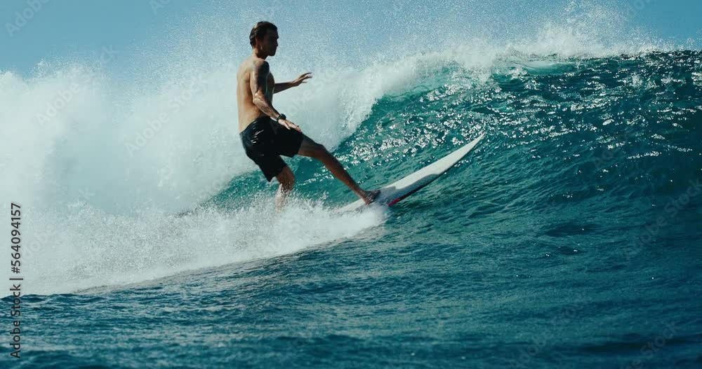 Surfer riding blue ocean wave carving powerful turn, surfing ocean lifestyle, extreme sports, slow motion