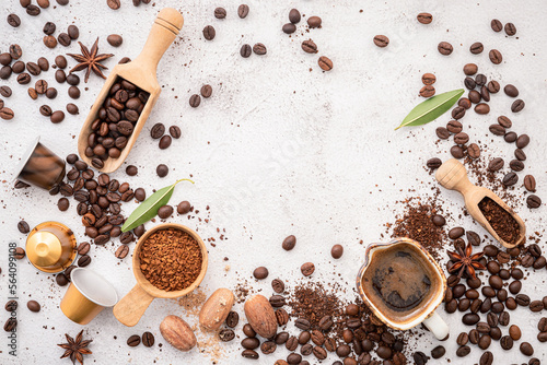 Background of various coffee , dark roasted coffee beans , ground and capsules with scoops setup on white concrete background with copy space.