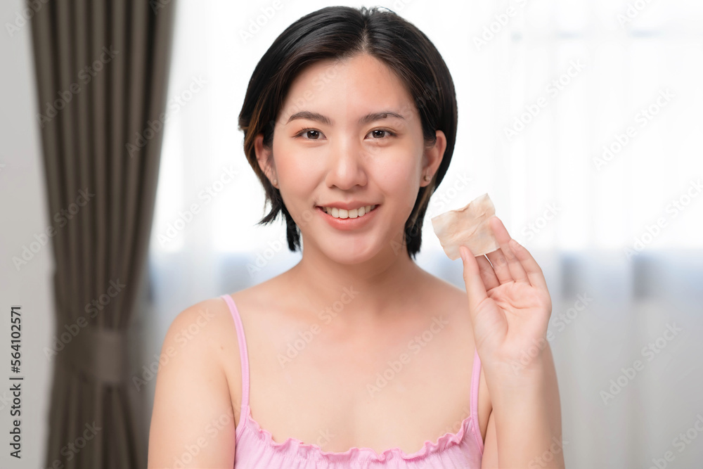 Asian women are using cotton pads moistened with cleansing wipes to remove make-up on their faces.