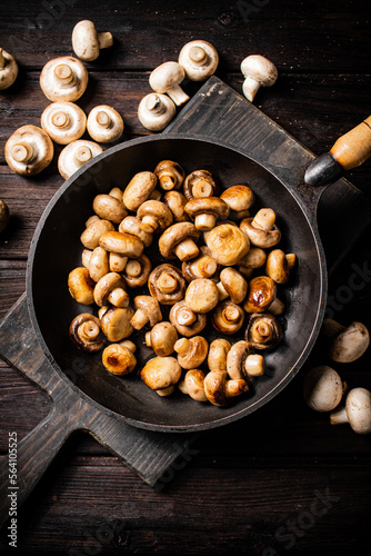 Fragrant homemade fried mushrooms in a frying pan on a cutting board. 
