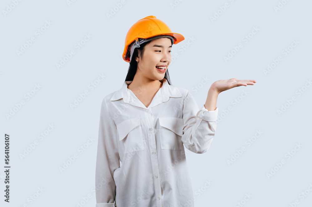 Young asian engineer female standing with open palm posture Young asian engineer female standing with open palm posture