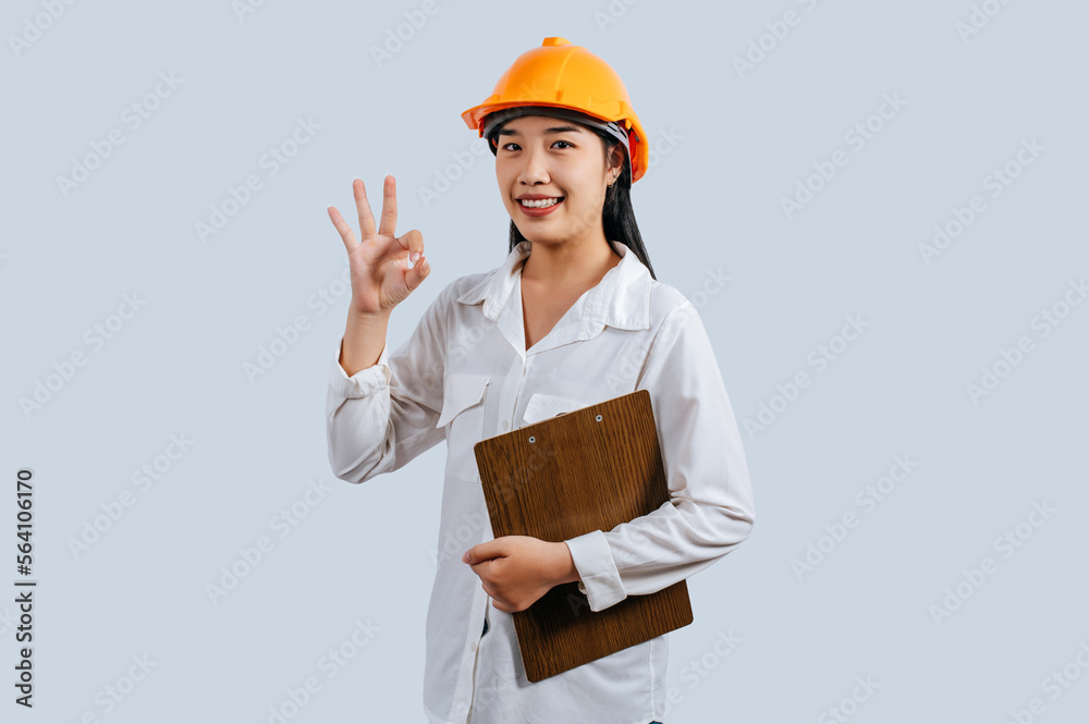 Young female engineer wearing Yellow helmet and clipboard