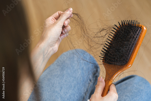 Serious asian young woman, girl hand in holding comb, show her hairbrush with long loss hair problem after brushing, hair fall out problem. Health care, beauty with copy space on floor background.