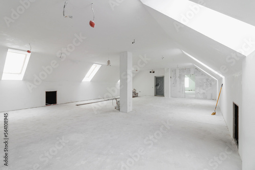 Spacious empty rooms in the attic floor after filling out the work on the wall and ceiling