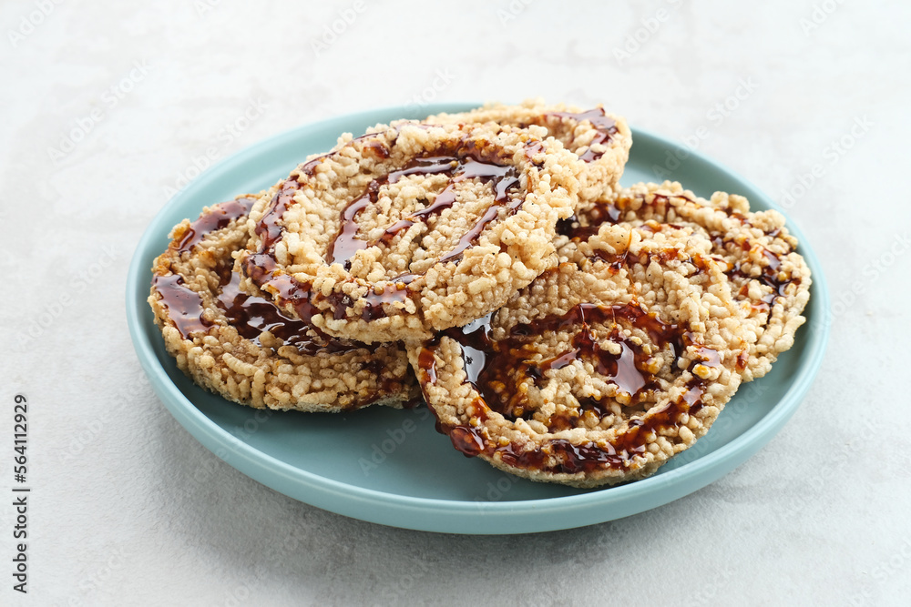 Rice crackers (intip madu or rengginang) with brown sugar on white background. Savory, sweet and crunchy.
Rice crackers (intip madu or rengginang) with brown sugar on white background. Savory, sweet and crunchy.