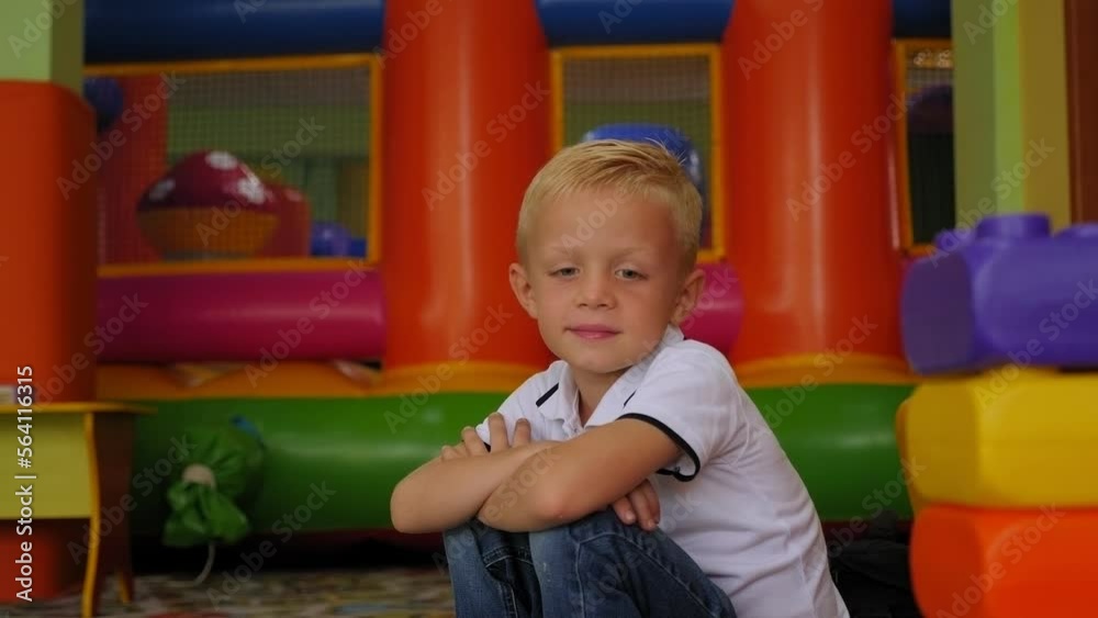 Portrait of a small boy with blond hair in a children's play center, he is looking at the camera. Portrait of a small boy with blond hair in a children's play center, he is looking at the camera.
