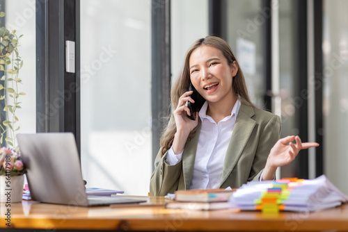 Everyday winner Excited Asian woman raising her arms while sitting at the desk in office, Happy excited employees work or business successful concept.