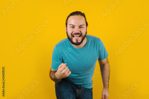 Portrait of young hispanic man with positive energy on yellow background in Mexico Latin America