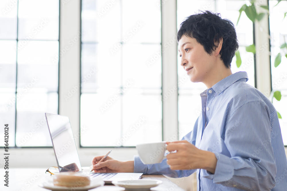 ノートパソコンを開きオンライン授業を受ける女性 ノートパソコンを開きオンライン授業を受ける女性