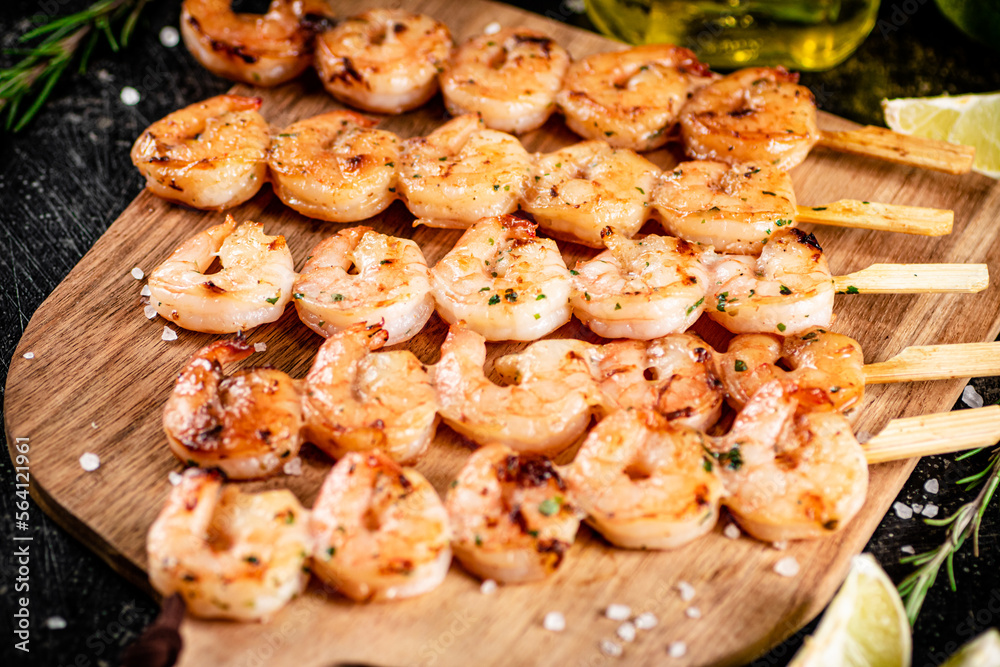 Grilled shrimp on a wooden cutting board. 