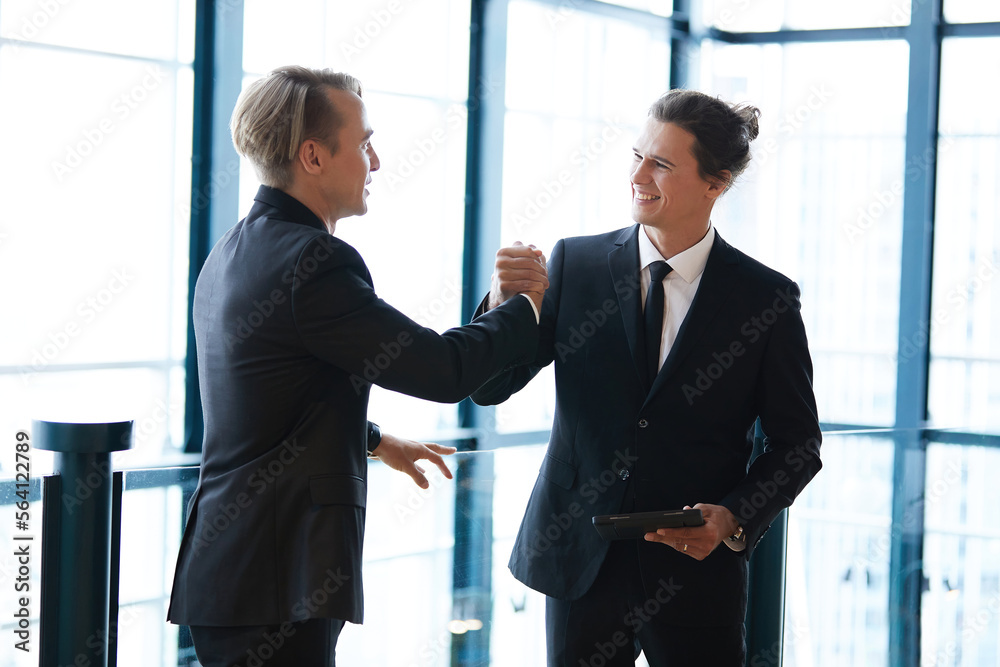 businessman shaking hands with friends and having fun in the office businessman shaking hands with friends and having fun in the office
