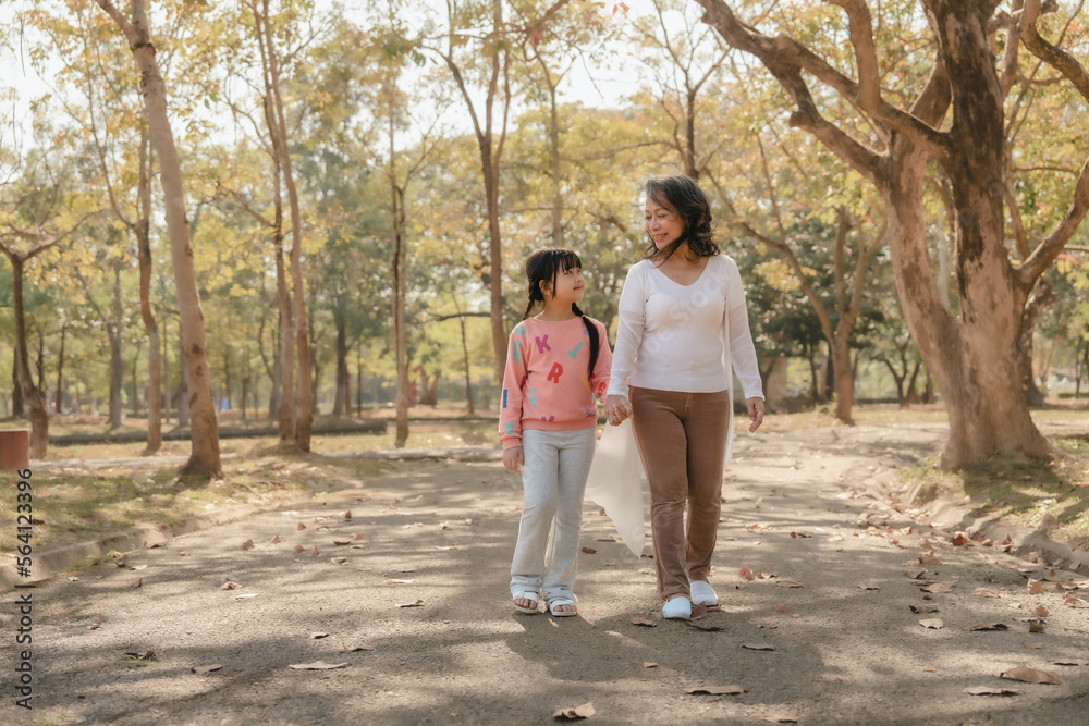 Portrait of asia grandmother and grandchildren holiday vacation together in the park in the summer in Southeast Asia Pacific. Walking Portrait of asia grandmother and grandchildren holiday vacation together in the park in the summer in Southeast Asia Pacific. Walking