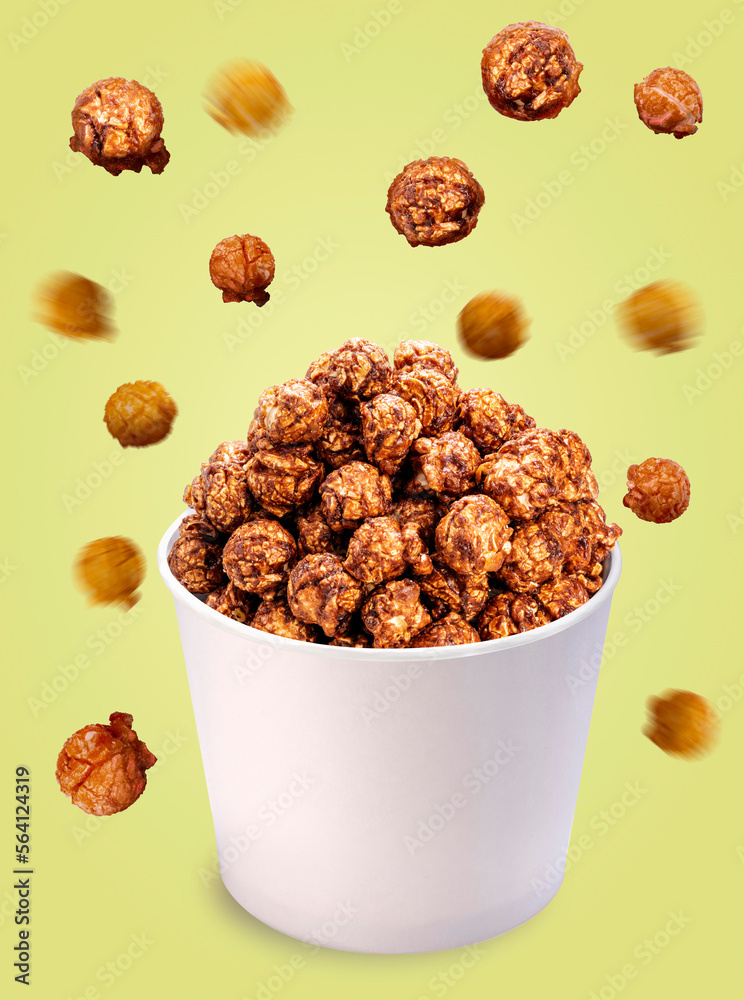 Caramel Popcorn on paper bucket isolated on yellow background, Mushroom Popcorn on yellow With work path. Caramel Popcorn on paper bucket isolated on yellow background, Mushroom Popcorn on yellow With work path.