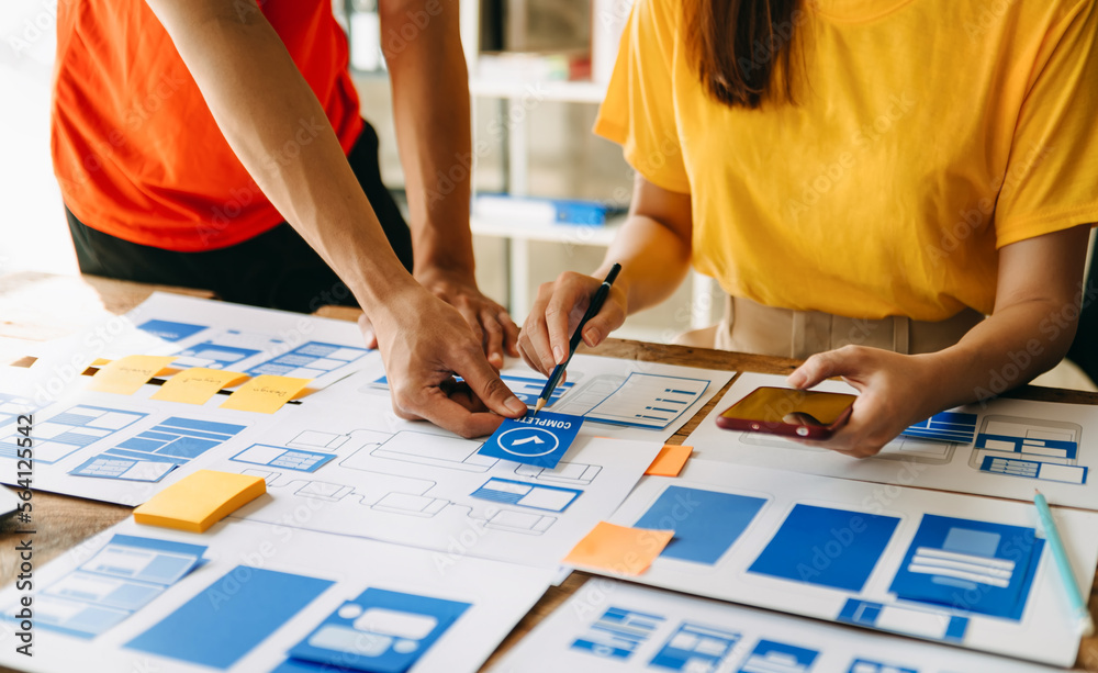 UX developer and ui designer brainstorming about mobile app interface wireframe design with customer breif and color code at modern office.. UX developer and ui designer brainstorming about mobile app interface wireframe design with customer breif and color code at modern office..