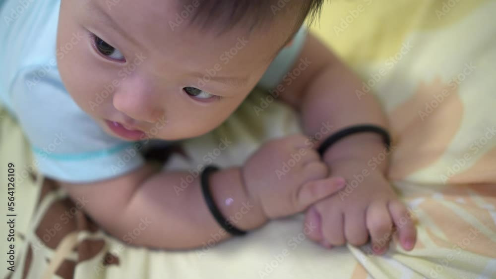 Selective focus the sleepy face of lying down baby on bed Selective focus the sleepy face of lying down baby on bed