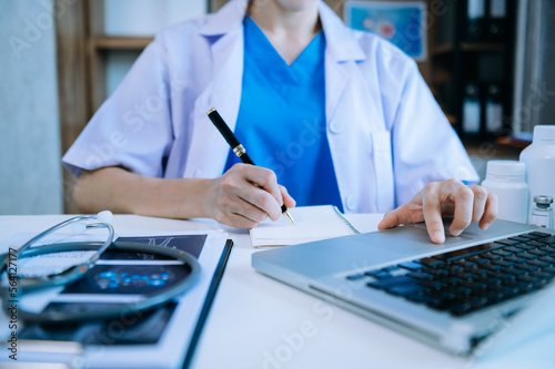 Medical technology concept. Doctor working with mobile phone and stethoscope and digital tablet laptop in modern office at hospital in morning light.