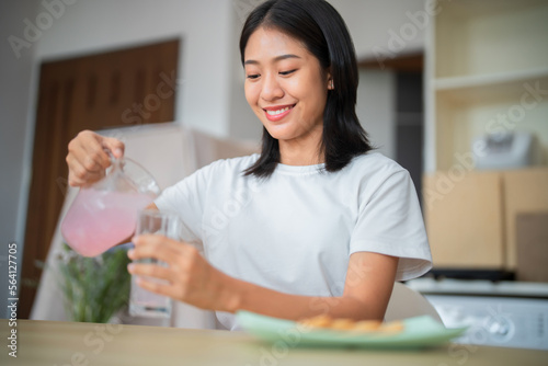 Happy Asian woman eating breakfast at her home, lifestyle concept.