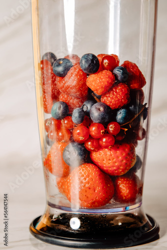 Fruit in a blender, mixer. Fruit cocktail and healthy food and drinks. Strawberry, raspberry, blueberry. Diet and vitamins for health, nutrition, smoothie diet.