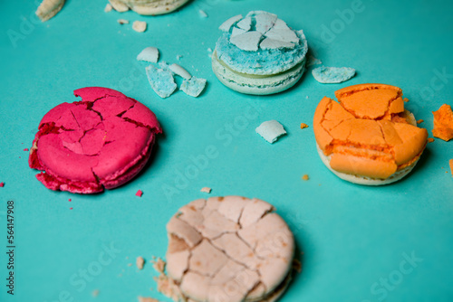 Crushed, broken macaron, French colored dessert on a blue background. photo