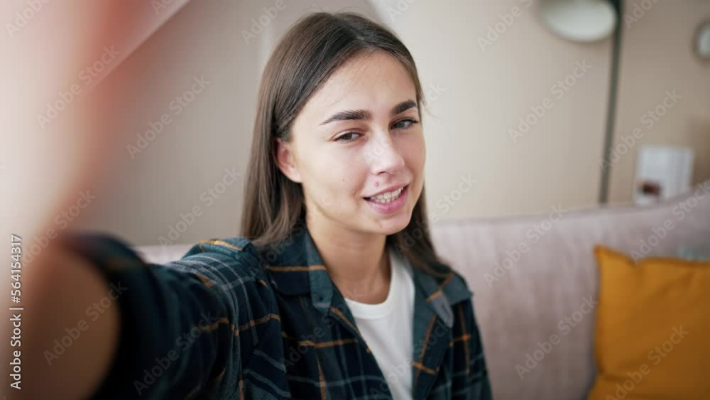 Smiling young caucasian woman vlogger make video call, looking at camera, recording vlog at home, talking. View from front camera to portrait video recording, girl holds mobile phone in hands. Smiling young caucasian woman vlogger make video call, looking at camera, recording vlog at home, talking. View from front camera to portrait video recording, girl holds mobile phone in hands.