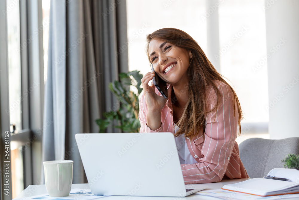 Young pretty businesswoman in the office sitting in office chair, talking on her smartphone Young pretty businesswoman in the office sitting in office chair, talking on her smartphone