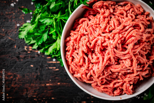 Minced fresh meat in a bowl with parsley. 