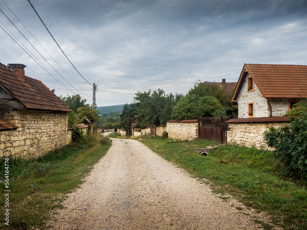 country houses in the village. dirt road crossing a village with stone houses. Chidea village from Cluj