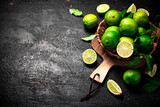 Ripe lime in a basket on a cutting board. 