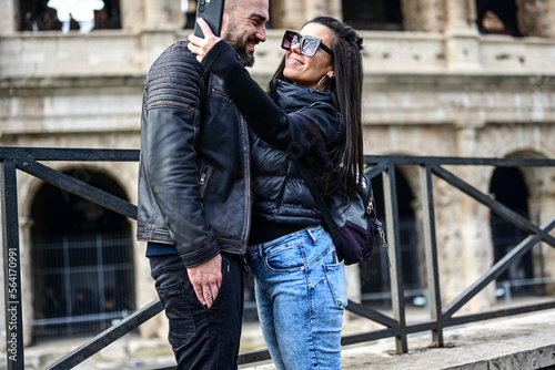 Happy  Tourists  couple traveling at Rome, Italy, poses in front of  Colosseum  at, Rome, Italy