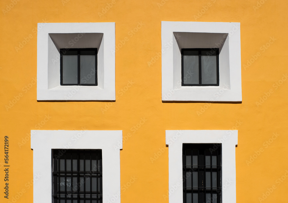 white windows on the yellow wall