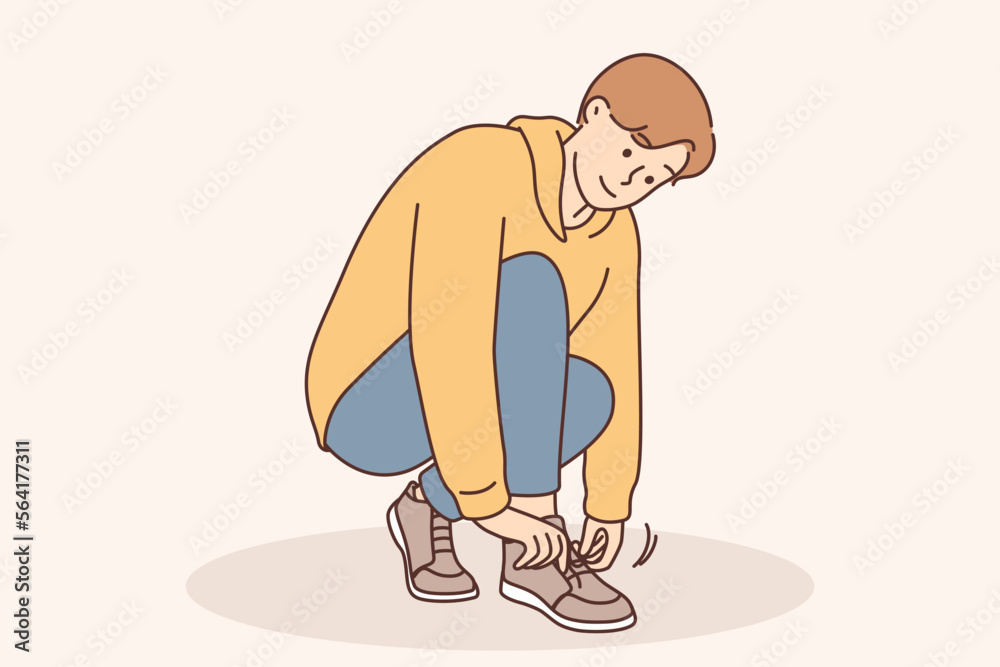 A little boy ties a shoelace on his shoe A little boy ties a shoelace on his shoe