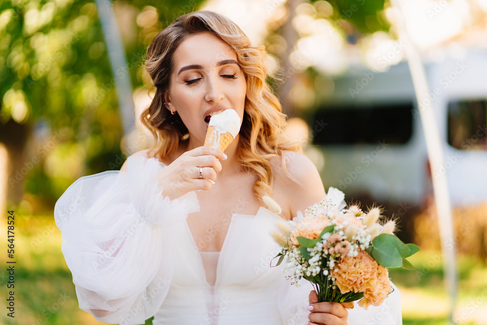 the bride eats an ice cream cone in the park