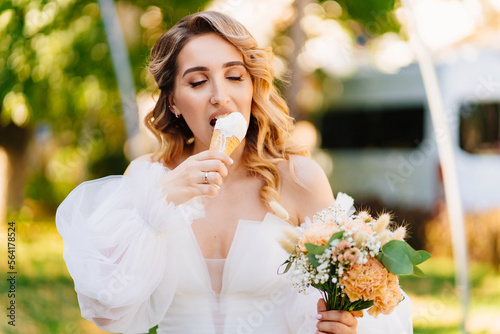 Bild auf Leinwand the bride eats an ice cream cone in the park