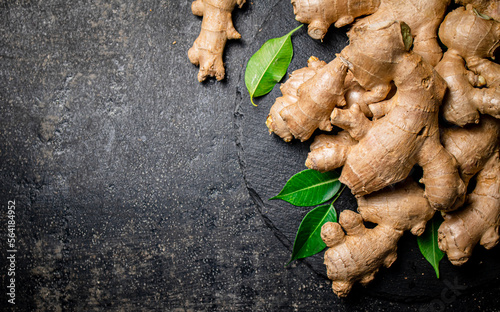 Fresh ginger with leaves on a stone board.  © Artem Shadrin