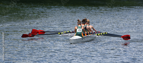 Ladies Fours Sculling Team Rowing on River. photo