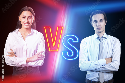 Attractive young businesswoman versus businessman on blurry dark neon background. Competition, battle and macth concept. photo