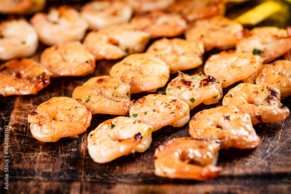 Grilled shrimp on a wooden cutting board.