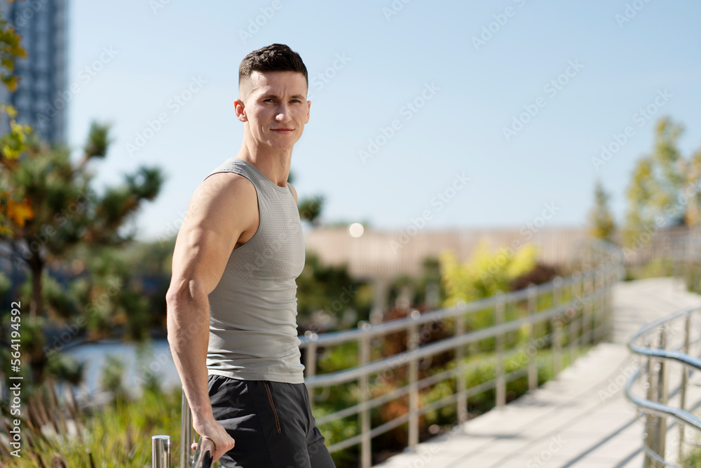 Portrait view of the handsome fitness model posing wearing sport clothes