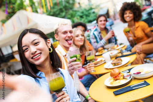 Multiracial young people together meeting and having party in a restaurant - Group of friends taking selfie while celebrating in a bar- Friendship and lifestyle concepts