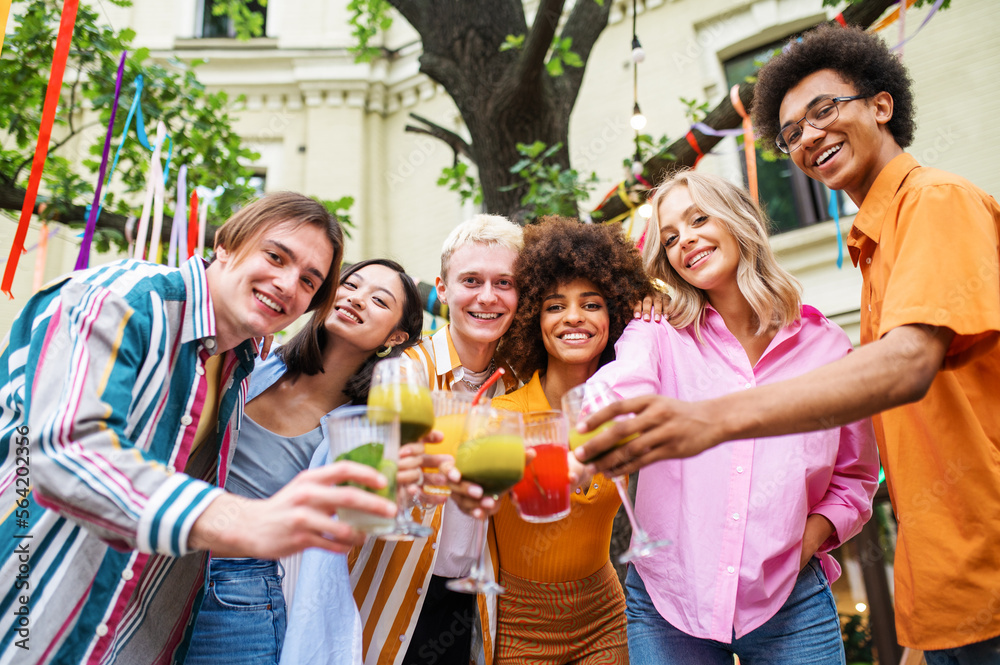 Obraz premium Multiracial young people together meeting and having party in a restaurant - Group of friends with mixed races having fun celebrating in a bar- Friendship and lifestyle concepts