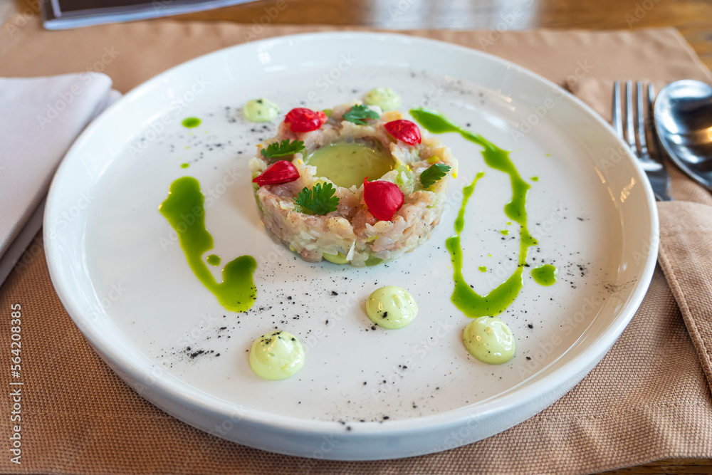 salad of various ingredients is beautifully arranged in the form of a ring on a white plate. salad of various ingredients is beautifully arranged in the form of a ring on a white plate.