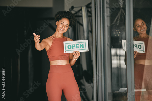 Black woman, welcome and gym owner with open sign for fitness or coaching exercise. Portrait of African American female, sports entrepreneur and training manager or personal trainer at entrance