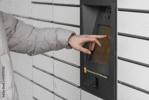 Shopping locker inPost with man's hand entering code to open it. E-commerce shipping and delivery concept.