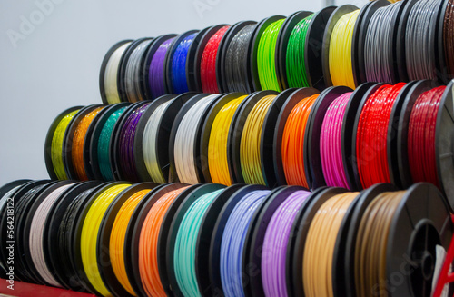 Many multi-colored spools of thread of filament for printing 3d printer. Material coils for printing 3D printer. Spools of 3D printing motley different colors filament. ABS wire plastic for 3d printer