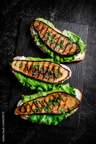 Grilled eggplant sandwich on a stone board. 