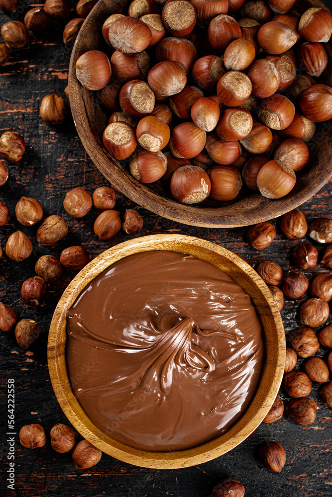 Hazelnut butter and inshell hazelnuts on the table in plates. Hazelnut butter and inshell hazelnuts on the table in plates.